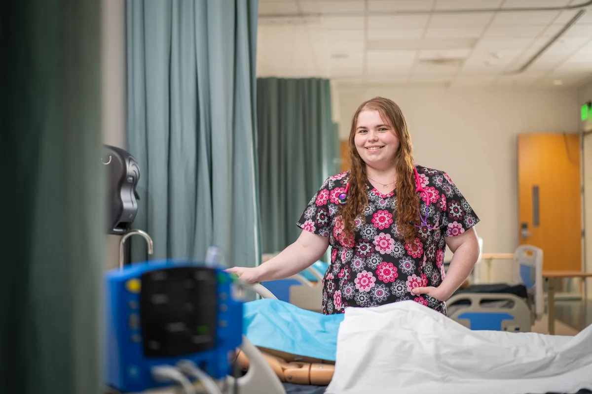 Nursing student in scrubs practicing clinical skills in a Laurel Ridge lab